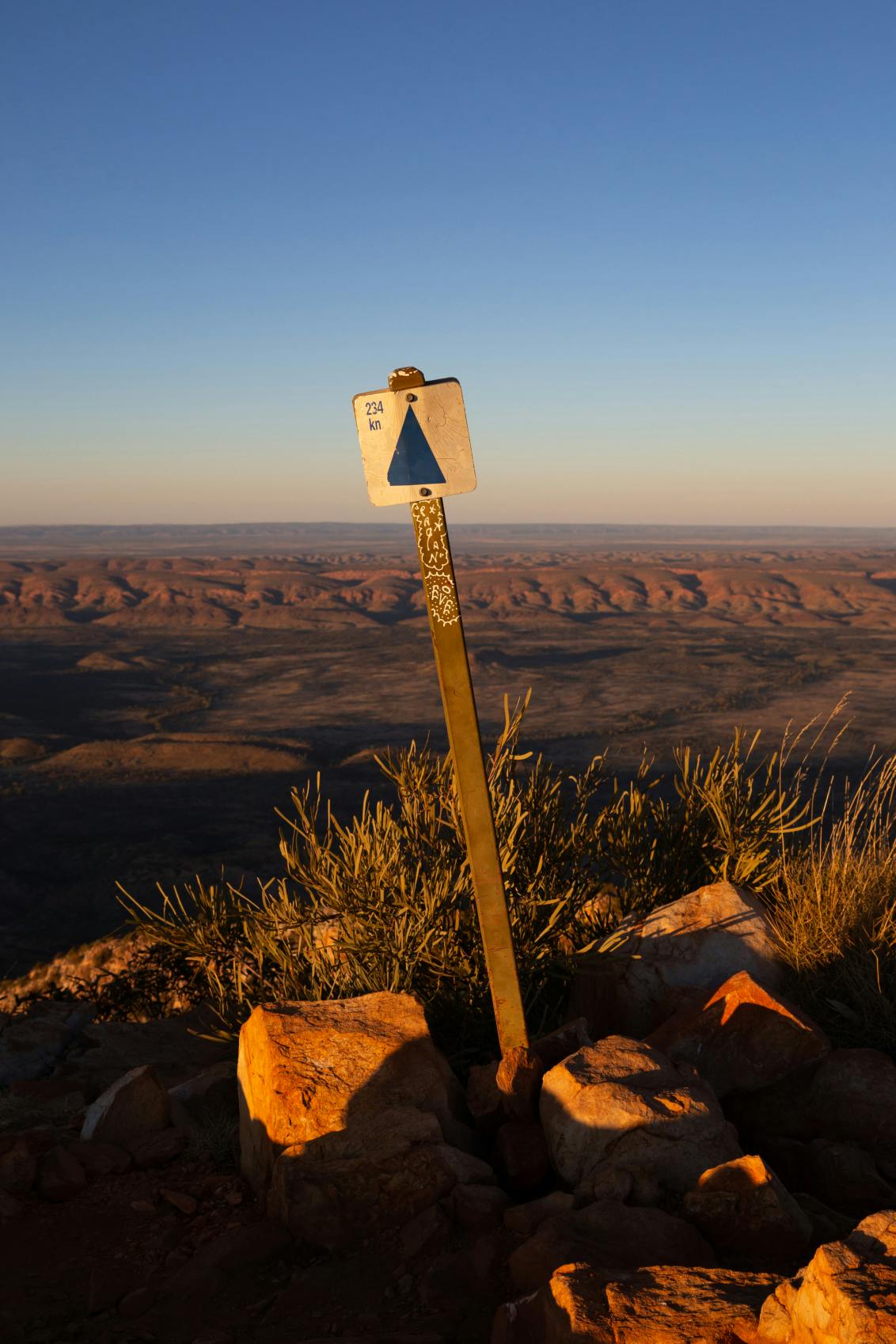 Sign indicating distance in Australian outback - experience a multi-day journey with short hikes along the Larapinta trail